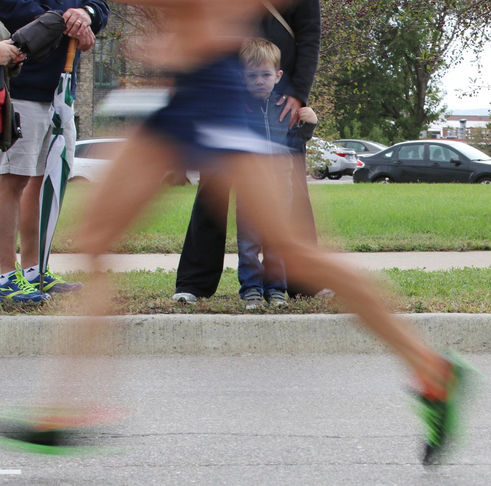 boy watching marathon runners